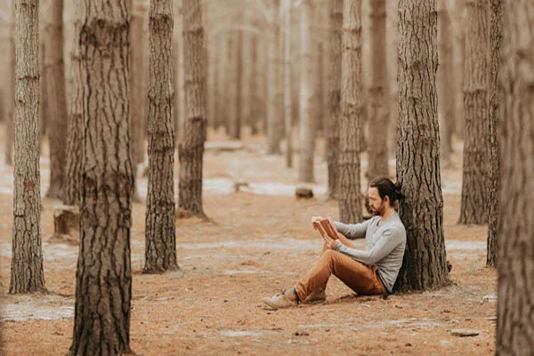 Best Daily Devotional for Men - Man reading in woods