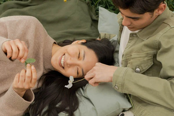 Best Devotionals for 20 Somethings - dating couple sitting/laying on grass