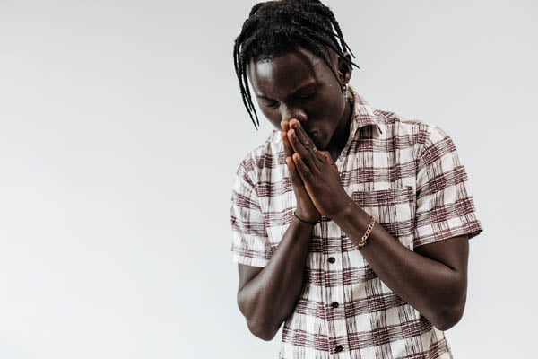 Man with braids praying